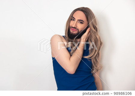 Pleased travesty man touching his peruke during the photo shoot 98986106
