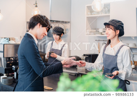 Businessman making credit card payment at a cafe Businessman making credit card payment at a cafe 98986133