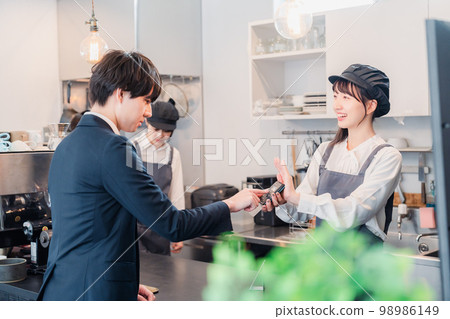 Businessman making credit card payment at a cafe Businessman making credit card payment at a cafe 98986149
