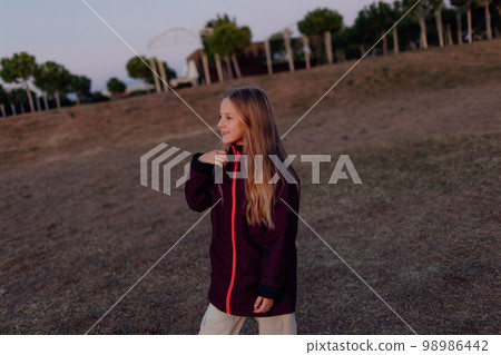 Soft focus of little girl's hair while she is playing with someone actively on a field at sunset Soft focus of little girl's hair while she is playing with someone actively on a field at sunset 98986442
