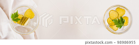 Cold pickleback cocktail with pickles and parsley in glasses on the table. Top view. Web banner 98986955