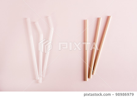 Choice between glass and paper straws for drinks. Zero waste. Top view. Choice between glass and paper straws for drinks. Zero waste. Top view. 98986979