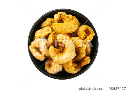 Top view of homemade crispy delicious deep fried pork rinds in black ceramic bowl. Top view of homemade crispy delicious deep fried pork rinds in black ceramic bowl. 98987417