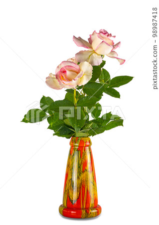 Side view of blooming beautiful pink roses with leaves decorated in colorful ceramic vase. Side view of blooming beautiful pink roses with leaves decorated in colorful ceramic vase. 98987418