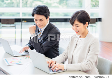 工作在辦公室的男性和女性商人 工作在辦公室的男性和女性商人 98988224