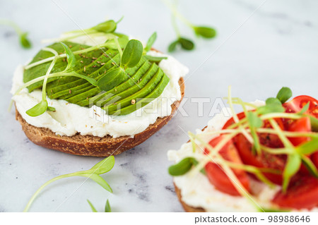 Toast with cream cheese, avocado and micro greens. Healthy breakfast concept. Toast with cream cheese, avocado and micro greens. Healthy breakfast concept. 98988646