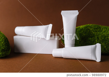 Moisturizer cream white tubes among natural green moss 98988972