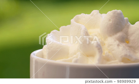 Putting whipping cream into a cup Putting whipping cream into a cup 98989929