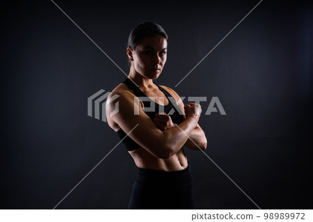 Strong sportswoman in boxing gloves prepared high kick. Isolated on white, red, yellow background 98989972