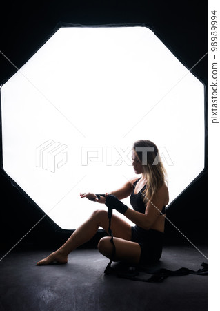 Strong sportswoman in boxing gloves prepared high kick. Isolated on white, red, yellow background 98989994