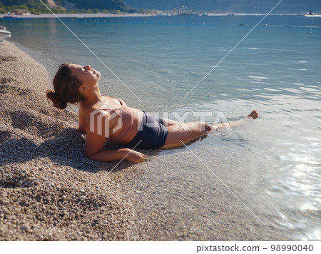 Cheerful woman enjoying the beach 98990040