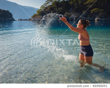 Cheerful woman enjoying the beach 98990041