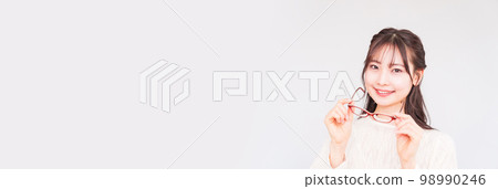 A young woman at an ophthalmologist takes off her glasses for a vision test [ Image of LASIK ] 98990246