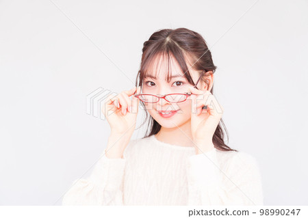 A young woman at an ophthalmologist takes off her glasses for a vision test [ Image of LASIK ] 98990247