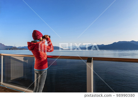 Alaska Glacier Bay cruise ship passenger looking at Alaskan mountains on Vacation adventure Alaska Glacier Bay cruise ship passenger looking at Alaskan mountains on Vacation adventure 98990380