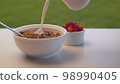 Milk pouring into corn flakes 98990405