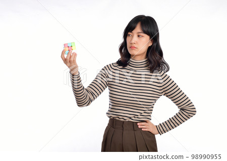 Asian woman holding a rubik cube standing on white background. solving cubic problems, problem solution and making strategic moves concept Asian woman holding a rubik cube standing on white background. solving cubic problems, problem solution and making strategic moves concept 98990955
