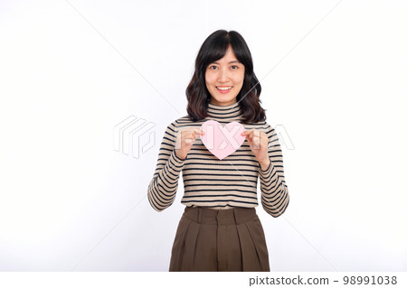 Beautiful young asian woman holding a paper heart while standing against white background. Beautiful young asian woman with paper heart. 98991038