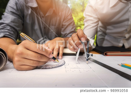 Confident team of architect working together in a office.They discussing about new startup project on desk. Architect discuss with engineer about project in office, architectural concept Confident team of architect working together in a office.They discussing about new startup project on desk. Architect discuss with engineer about project in office, architectural concept 98991058