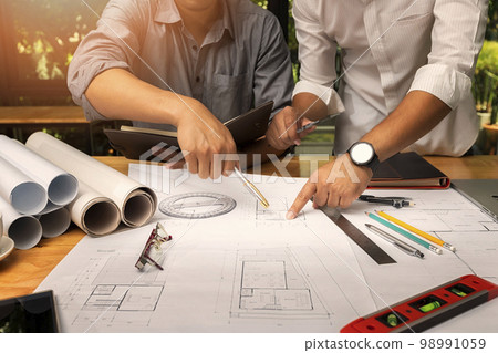 Confident team of architect working together in a office.They discussing about new startup project on desk. Architect discuss with engineer about project in office, architectural concept 98991059