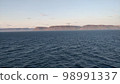 Mountainous coastline of Greenland as seen from the deep blue waters of the Atlantic Ocean in the early morning 98991337