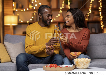 Cheery black spouses celebrating weekend at home, have dinner 98992113