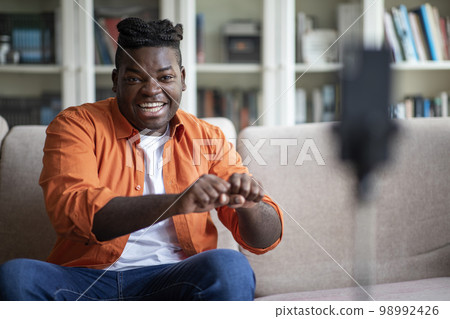 Cheerful african guy fooling wile recording video on smartphone 98992426