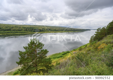 View of the Tom River in the Siberian taiga under a stormy sky in summer 98992552