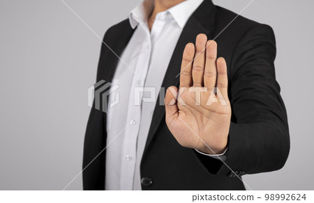 Man In Suit Showing Open Palm At Camera, Gesturing Stop Man In Suit Showing Open Palm At Camera, Gesturing Stop 98992624