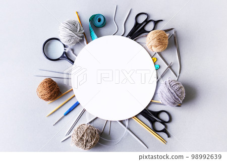 Knitting accessories, knitting hook, knitting needles, scissors, magnifying glass, needles, centimeter and balls of thread with space for text. Flat lay Knitting accessories, knitting hook, knitting needles, scissors, magnifying glass, needles, centimeter and balls of thread with space for text. Flat lay 98992639