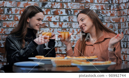 Young girls eat in a cafe and talk. Young girls eat in a cafe and talk. 98992744