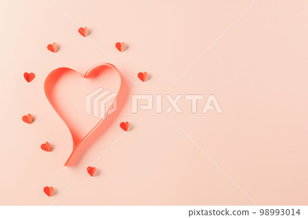 Love and Valentines Day background. Top view flat lay of Ribbons shaped as heart and paper elements cutting red hearts flying on pink background, Banner template greeting card design of holiday 98993014