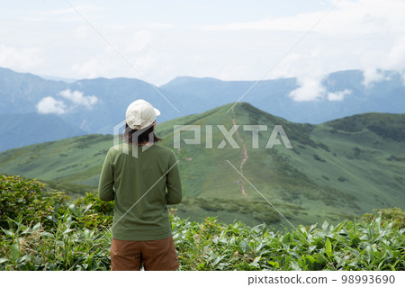 一個女人在夏日山中欣賞風景的背影 98993690