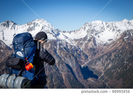 一個在北阿爾卑斯山的帳篷裡徒步旅行的人 98993856