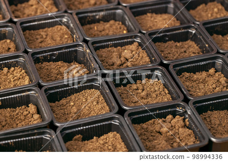 Plastic pots with fertile soil for planting seeds and seedlings Plastic pots with fertile soil for planting seeds and seedlings 98994336