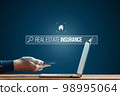 Person works on smartphone and laptop. Looking for insurance on the Internet for real estate. Risk of an earthquake. 98995064