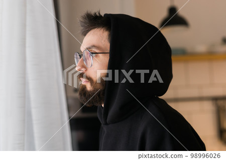 Side view of man longing and looking through window in sad day - depression and melancholy concept Side view of man longing and looking through window in sad day - depression and melancholy concept 98996026