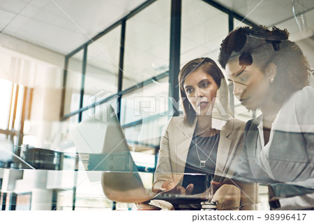 Business people, laptop and meeting conversation planning tech strategy, online marketing or teamwork collaboration. Corporate women, web design and ux designers talking with digital device in office 98996417