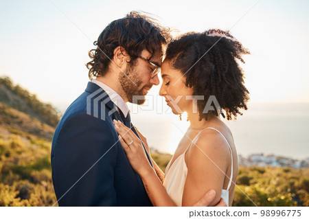 Wedding, interracial couple love and worship of people outdoor for marriage and save the date. Close, celebration and bride with man for commitment, care together feeling calm in nature Wedding, interracial couple love and worship of people outdoor for marriage and save the date. Close, celebration and bride with man for commitment, care together feeling calm in nature 98996775