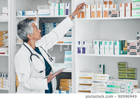 Pharmacy, tablet and medicine with senior woman in store for healthcare, wellness or retail. Product, technology and stock with pharmacist checking drugs outlet for shopping, medical or inventory Pharmacy, tablet and medicine with senior woman in store for healthcare, wellness or retail. Product, technology and stock with pharmacist checking drugs outlet for shopping, medical or inventory 98996949