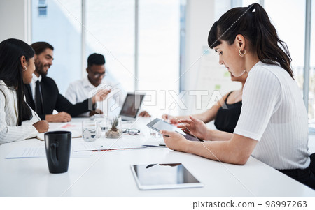 Woman, office and tablet at business meeting with analytics, planning and reading data with people. Corporate teamwork, mobile touchscreen tech or together for documents, finance or strategy 98997263