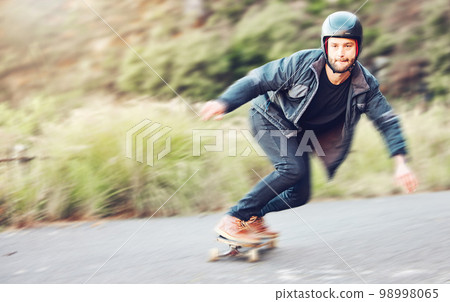 Sports, skateboard and man skating on road for fitness, exercise or wellness. Training, freedom and portrait of male skater moving with fast speed, skateboarding or riding outdoors for action workout Sports, skateboard and man skating on road for fitness, exercise or wellness. Training, freedom and portrait of male skater moving with fast speed, skateboarding or riding outdoors for action workout 98998065