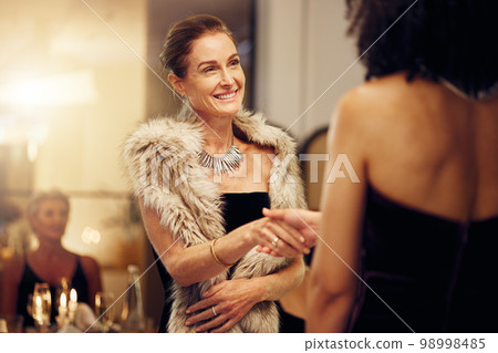 Success, handshake or women in a party shaking hands for partnership agreement at social event. Thank you, congratulations or happy people greeting or meeting at luxury dinner gala for winning a deal 98998485