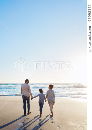 Family, beach and walk during sunset on vacation or holiday relaxing and enjoying peaceful scenery at the ocean. Sea, water and parents with daughter, child or kid with childhood freedom Family, beach and walk during sunset on vacation or holiday relaxing and enjoying peaceful scenery at the ocean. Sea, water and parents with daughter, child or kid with childhood freedom 98998553