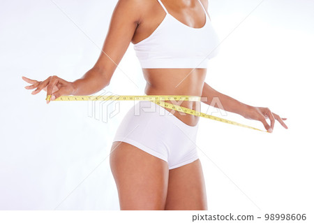 Measuring tape, stomach and woman in studio for wellness, weight loss and  tummy tuck on grey backgr Stock Photo by YuriArcursPeopleimages