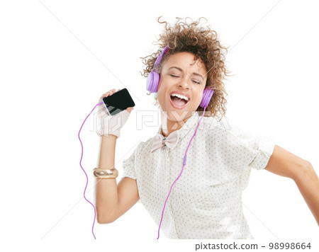 Dance, happy and black woman sing phone music, phone radio and online audio with freedom. White background, woman and happiness of isolated person streaming a dancing track with headphones and mobile Dance, happy and black woman sing phone music, phone radio and online audio with freedom. White background, woman and happiness of isolated person streaming a dancing track with headphones and mobile 98998664