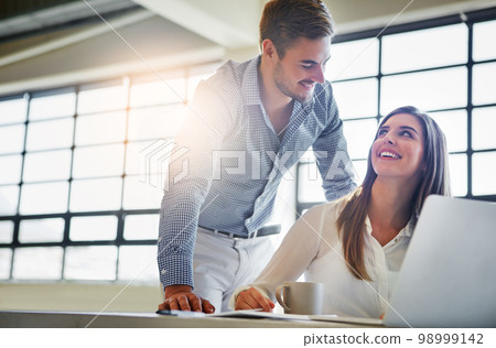 Training, coaching and business people with laptop in office workplace. Planning, manager and man helping woman on computer with advertising project, sales proposal or marketing strategy in company. 98999142