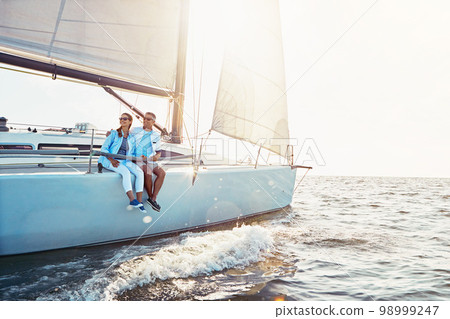 Happy couple, cruise ship and ocean in summer sunshine, love and romance on outdoor adventure. Couple, yacht and cruise sea with waves, bonding or peace with luxury, lifestyle and travel for vacation 98999247
