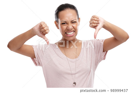 Woman, thumbs down and unhappy expression for disagreement, wrong or fail against a white studio background. Portrait of isolated female model showing down thumbs in disapproval, no or failure 98999437