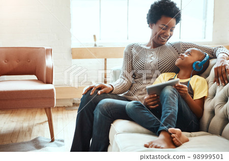 Tablet, relax and black family of kid, mom or African people relax together, bonding and enjoy quality time. Love, digital tech and youth child listening to music, streaming video or online gaming 98999501